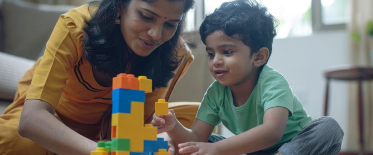Mother and young boy stacking colorful building blocks on a living room rug at home